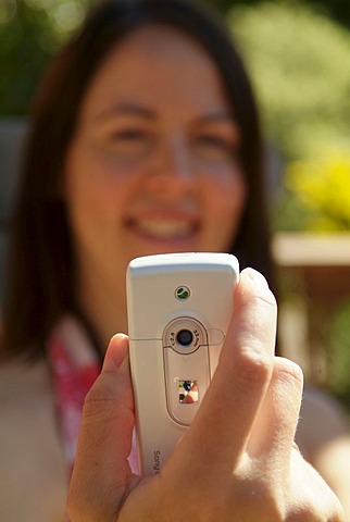 Woman photographs with photo mobile phone