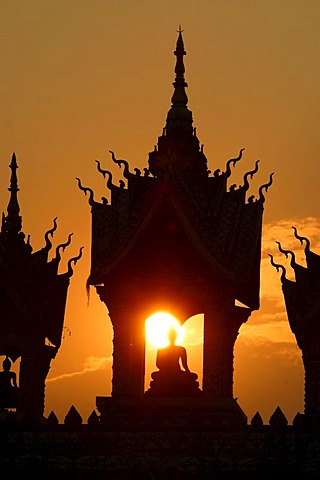 Sunset behind a Buddha statue at That Luang Vientiane, Laos, Asia