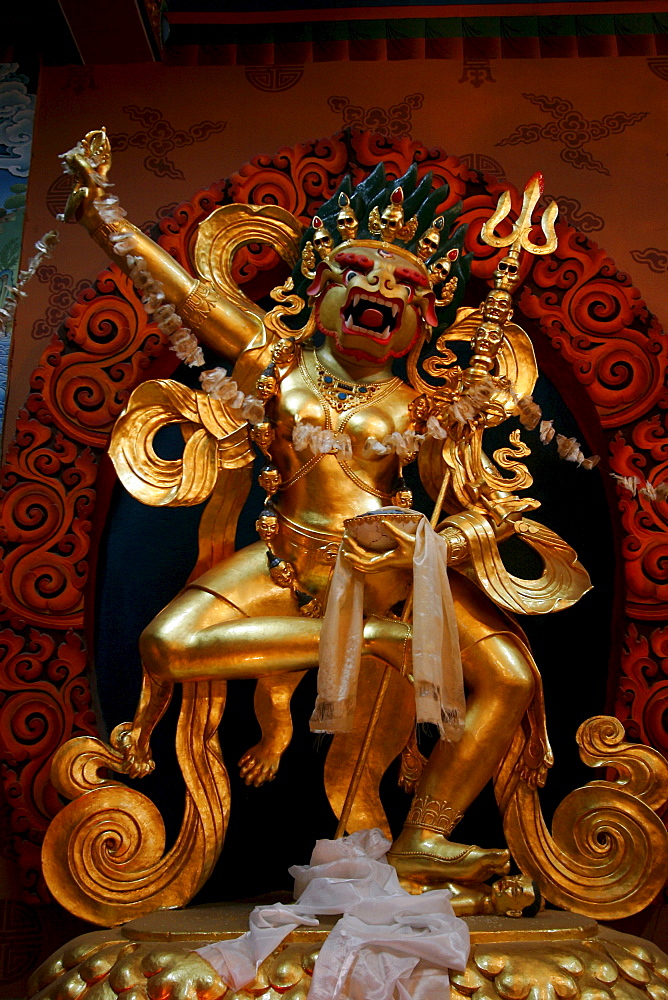 Golden statue of a gruesome demon in a monastery at the stupa near Bodnath, Kathmandu, Nepal, Asia