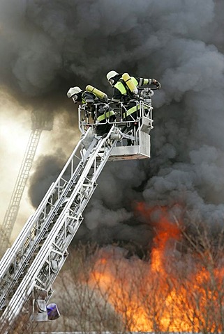 German fire brigade men fights a blaze in a warehouse in Munich Bavaria Germany.