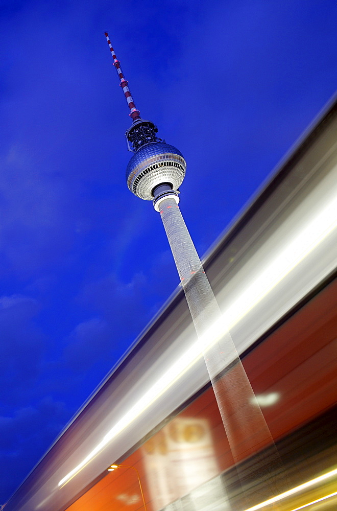 Time exposure of the Television Tower or Fernsehturm behind light streaks left by a passing car, Alexanderplatz, Berlin, Germany