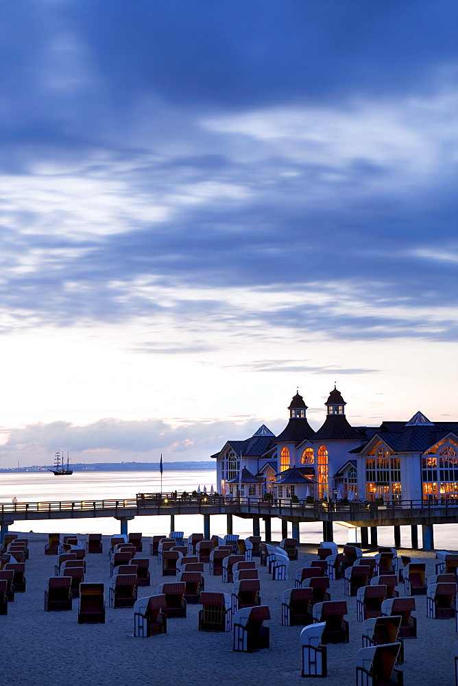 Pier behind rows of roofed wicker beach chairs, dusk, Sellin, Ruegen, Baltic Sea, Mecklenburg-Western Pomerania, Germany, Europe