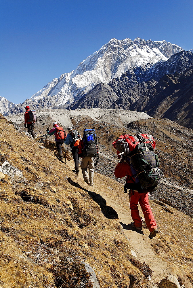 Trekking group on Khumbu glacier with Nuptse (7861), Khumbu Himal, Sagarmatha National Park, Nepal