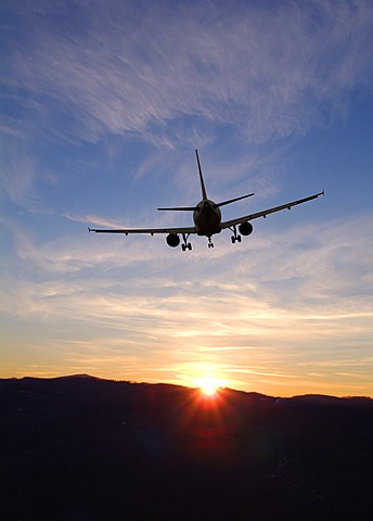 Airplane taking off into sunset