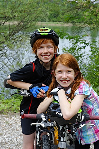 Two children, boy and girl, with mountain bikes and helmets