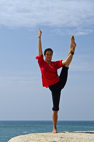 Woman in a yoga position, Anjaneyasana, by the sea in Kanyakumari, Tamil Nadu, India, Asia