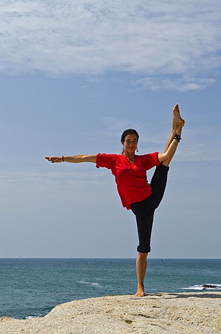 Woman in a yoga position, Anjaneyasana, by the sea in Kanyakumari, Tamil Nadu, India, Asia