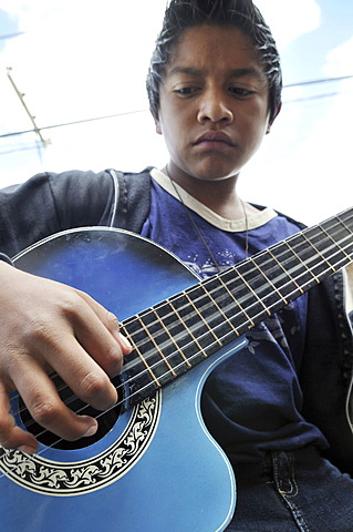 Teenager, 14 years old, practising on a guitar, slums of Cerro Norte, BogotÃ¡, Columbia