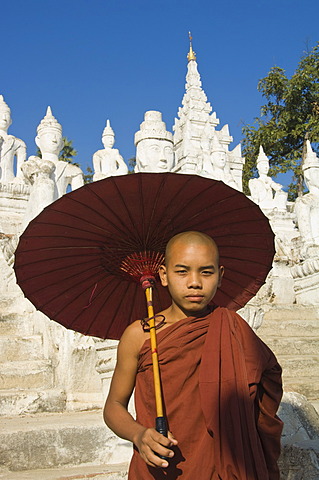 Young Buddhist monk with a red umbrella, Settawya Pagoda, Mingun, Burma, Myanmar, South East Asia