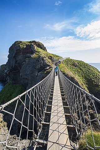 Carrick-a-Rede Bridge, woman standing on the suspension bridge, Moyle, Northern Ireland, United Kingdom, Europe