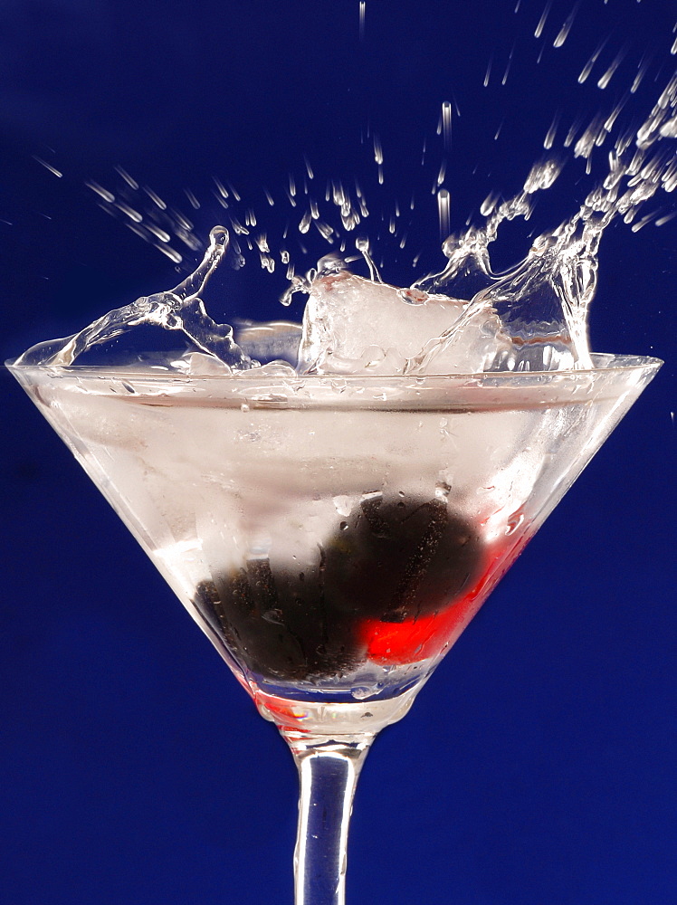 Cocktail glas with water splashing and fruits