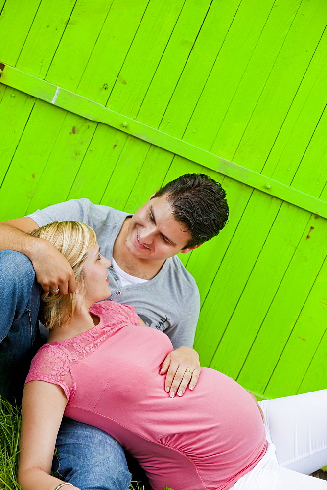 Pregnant woman lying in the arms of her husband