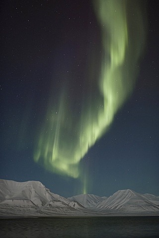 Green Northern Lights, Aurora Borealis, over the mountains of Longyearbyen lit by the crescent moon, Spitsbergen, Svalbard, Norway, Europe