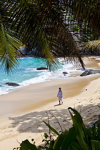 Woman walking along the beach wearing a tunic, MahÃ© Island, Seychelles, Indian Ocean, Africa