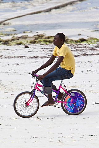 Bicycle rider on the beach at Pingwe, Zanzibar, Tanzania, Africa