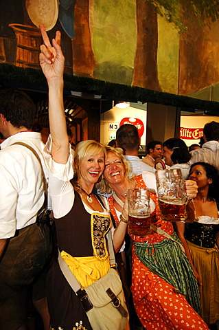 Women wearing traditional dress, called a Dirndl, dancing in the Beer Tent at the Oktoberfest Beer Festival or Wies\'n in Munich, Bavaria, Germany, Europe