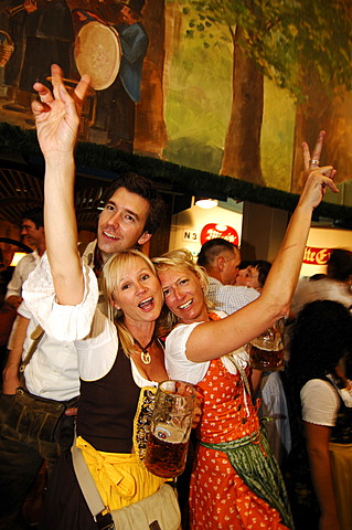 Women wearing traditional dress, called a Dirndl, dancing in the Beer Tent at the Oktoberfest Beer Festival or Wies\'n in Munich, Bavaria, Germany, Europe