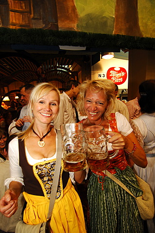 Women wearing a traditional dress, called a Dirndl, in a beer tent at the Oktoberfest Beer Festival or Wies\'n in Munich, Bavaria, Germany, Europe