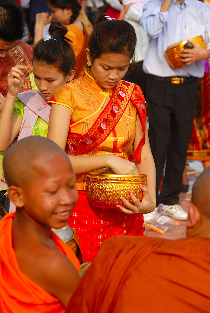 Theravada Buddhism, That Luang Festival, Tak Bat, novice, monks receive alms, Laotian believer with sash and alms bowl, pilgrims giving alms, orange robes, Vientiane, Laos, Southeast Asia, Asia