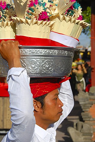 Balinese Hinduism, devout young man carrying a silver sacrificial bowl with gifts on his head, Pura Ulun Danu Batur temple, Batur village, Bali, Indonesia, Southeast Asia, Asia