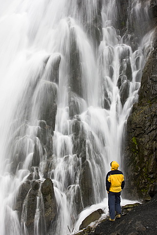 Waterfall with hiker near Seward, Alaska, USA