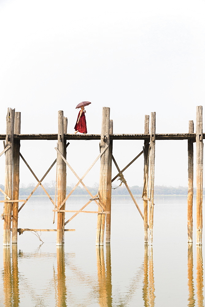 Monk crossing U Bein bridge, Taungthaman Lake, Mandalay region, Myanmar, Asia