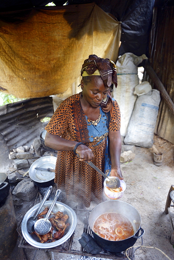 Woman is cooking in a simple kitchen, Riviere Froide, Ouest Department, Haiti, Central America