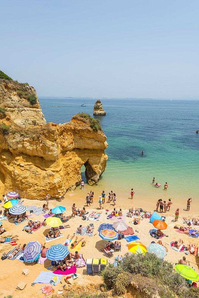 Tourists and bathers at the sandy beach, Praia do Camilo, Algarve rocky coast, Lagos, Portugal, Europe