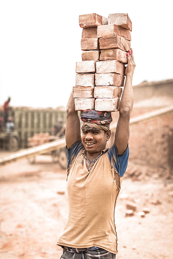 Worker with bricks on his head in the brickyard, Dhaka, Bangladesh, Asia