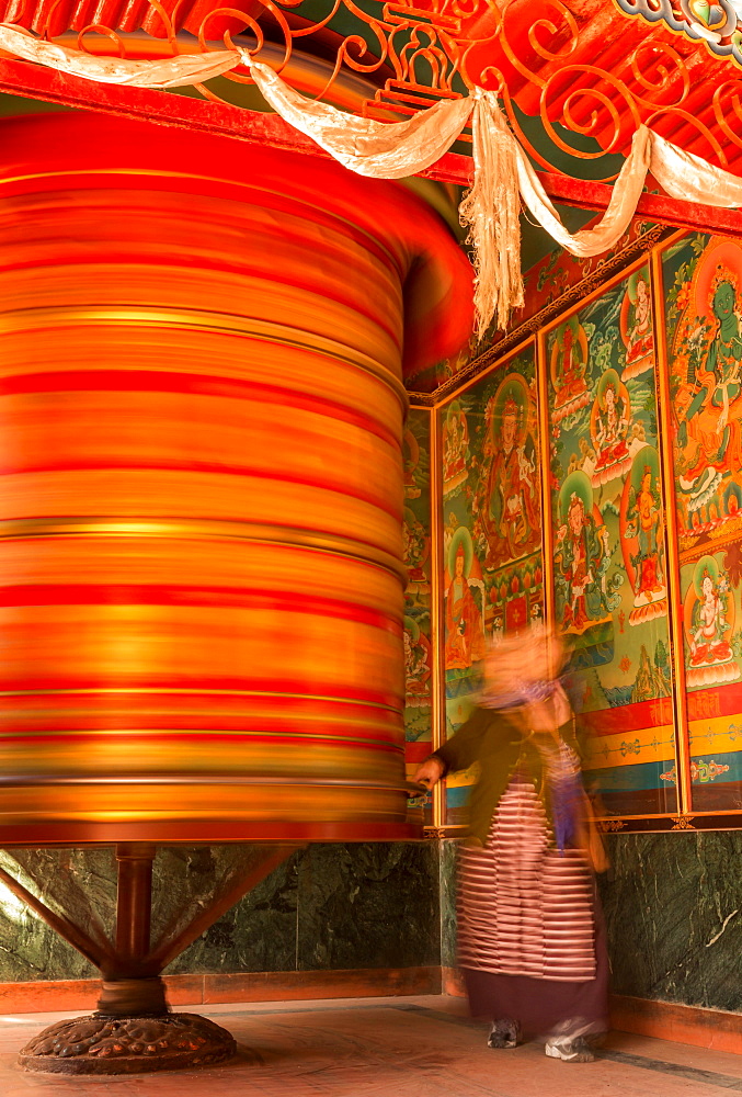 A female devotee spinning a large prayer wheel, Boudhanath, Kathmandu, Kathmandu District, Bagmati Zone, Nepal, Asia