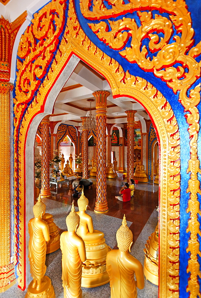 Ornate gate and golden Buddha statues, Wat Chalong temple, Phuket, Thailand, Asia