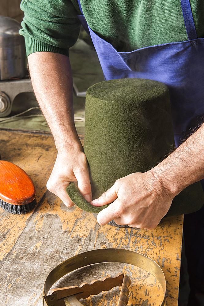 Man fitting wet hat body to wooden form, hatmaker workshop, Bad Aussee, Styria, Austria, Europe