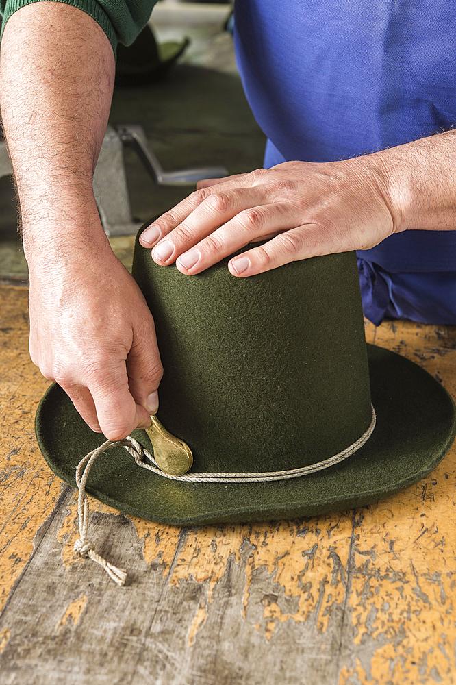 Tightening the shaping cord around a wool felt hat, using iron tool, hatmaker workshop, Bad Aussee, Styria, Austria, Europe