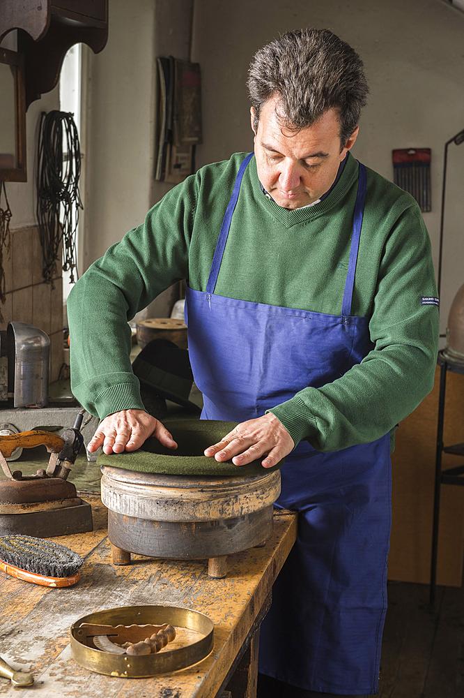 Hatter pushing dry wool felt hat into edge mold, hatmaker workshop, Bad Aussee, Styria, Austria, Europe