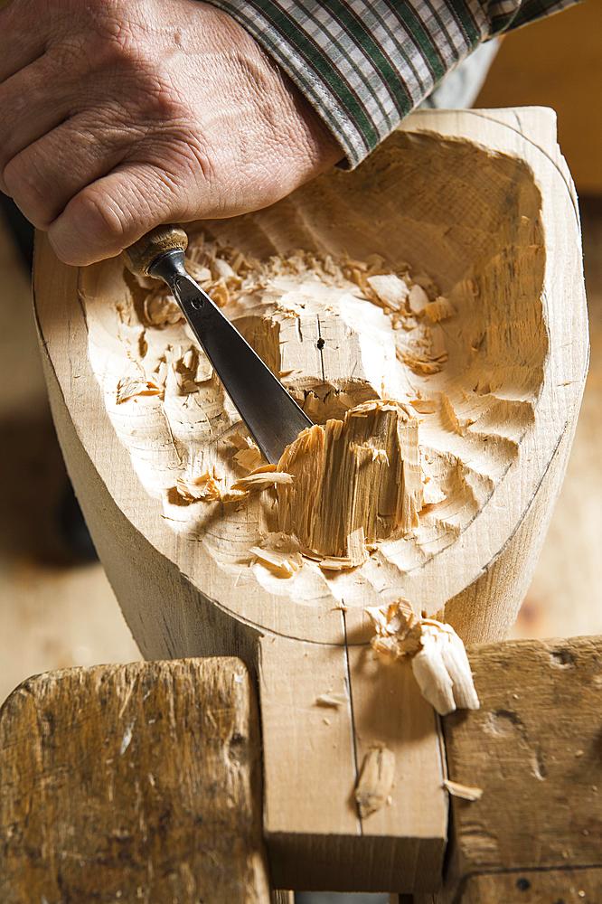 Carving the backside of a wooden mask using wood carving tools, wooden mask carver, Bad Aussee, Styria, Austria, Europe