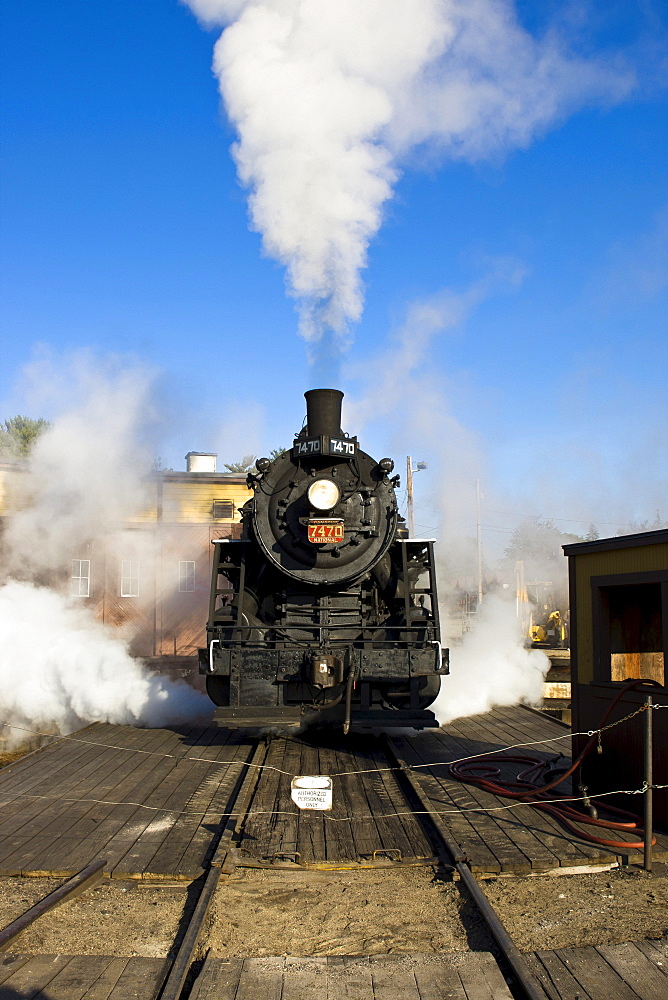 Old steam locomotive, 7470 model, driving in front of the heating house, Conway Scenic Railroad in Conway, New Hampshire, USA