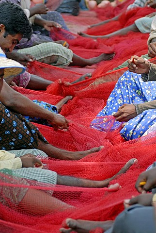 Fishermen mending a red fishing net, near Kasargod, Kerala, Malabar Coast, southern India, Asia