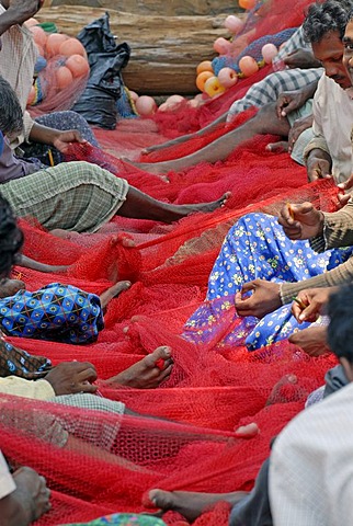 Fishermen mending a red fishing net, near Kasargod, Kerala, Malabar Coast, southern India, Asia