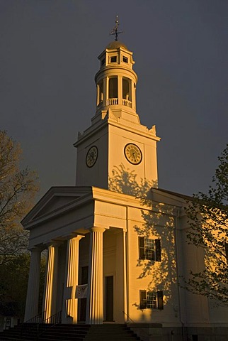 First Parish Church in front of dark thunderstorm clouds, illuminated by the last light of the day, Concord, Massachusetts, USA