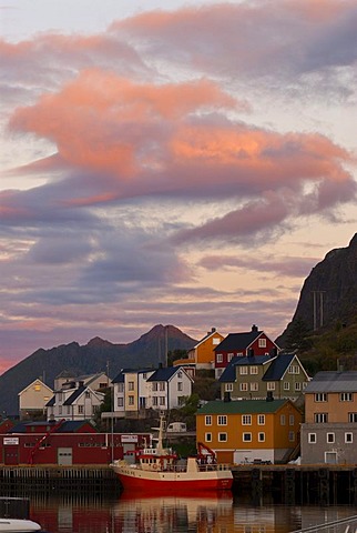 The boats and houses of Stamsund below colorful sunrise clouds, Nordland, Norway, Europe
