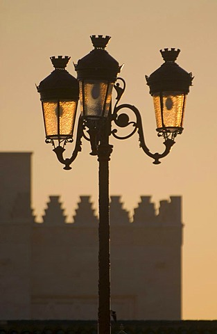 Backlit street lamps in front of the silhouette of the mausoleum of King Mohammed V, Rabat, Morocco, Africa