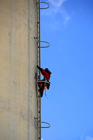 Chimney of Erlanger Stadtwerke heating plant, workman scaling chimney for repair works, Aussere Brucker Strasse 33, Elangen, Middle Franconia, Bavaria, Germany, Europe