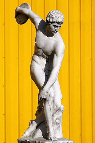 Sculpture of a Greek discus thrower, behind yellow metal panels, Herbolsheim, Baden-Wuerttemberg, Germany, Europe