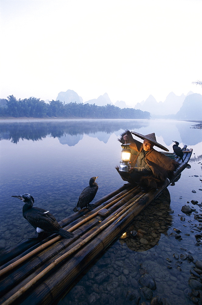 Cormorant fisherman at dawn on the Li River, Guilin, Yangshou, Guangxi Province, China, Asia