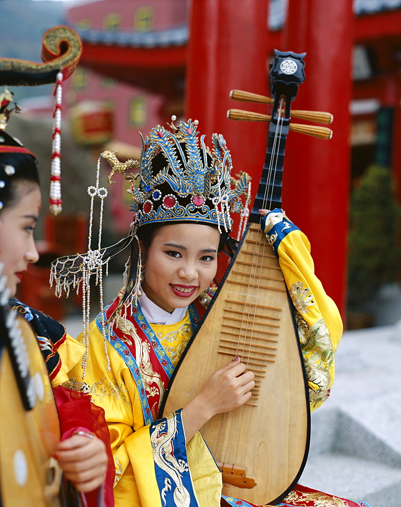 Woman dressed in traditional costume playing a three stringed lute, Beijing, China, Asia