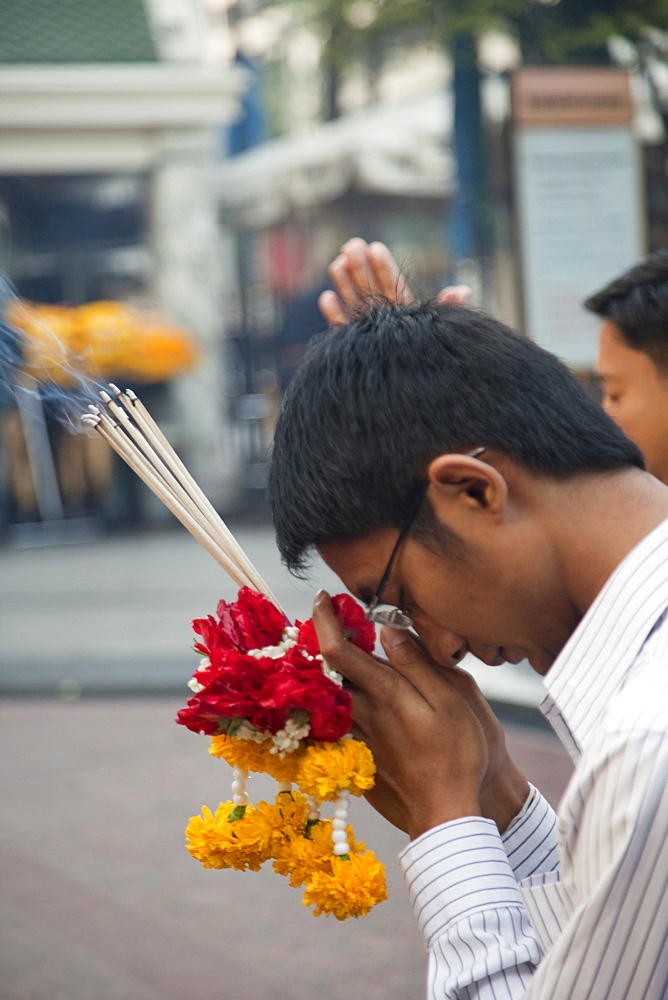 Man praying at Erawan Shrine, Bangkok, Thailand, Southeast Asia, Asia