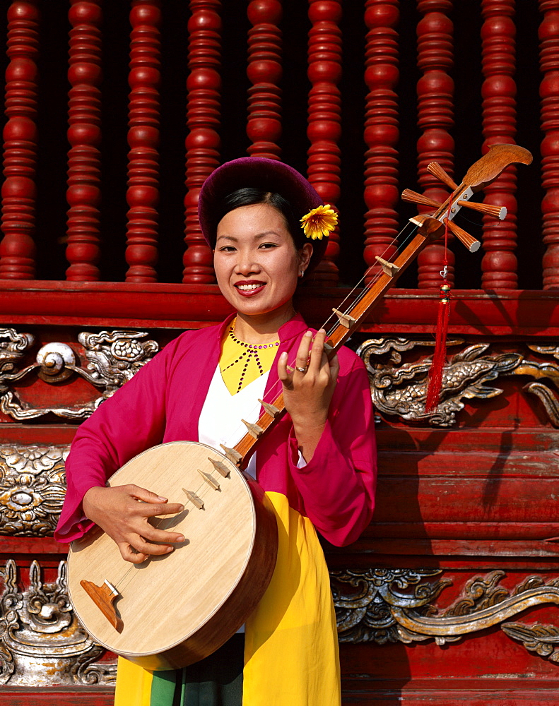 Woman dressed in traditional costume playing a stringed lute, Temple of Literature, Hanoi, Vietnam, Indochina, Southeast Asia, Asia