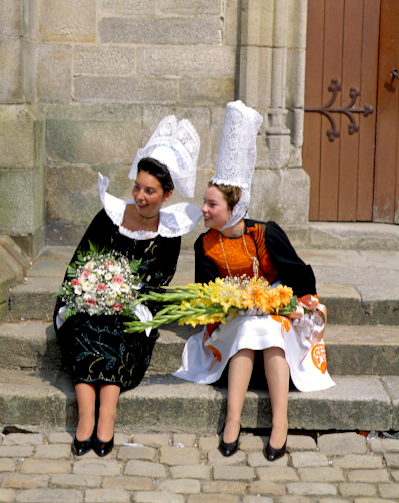 Two young women wearing lace headdresses (coiffes) and Breton traditional dress, Brittany, France, Europe