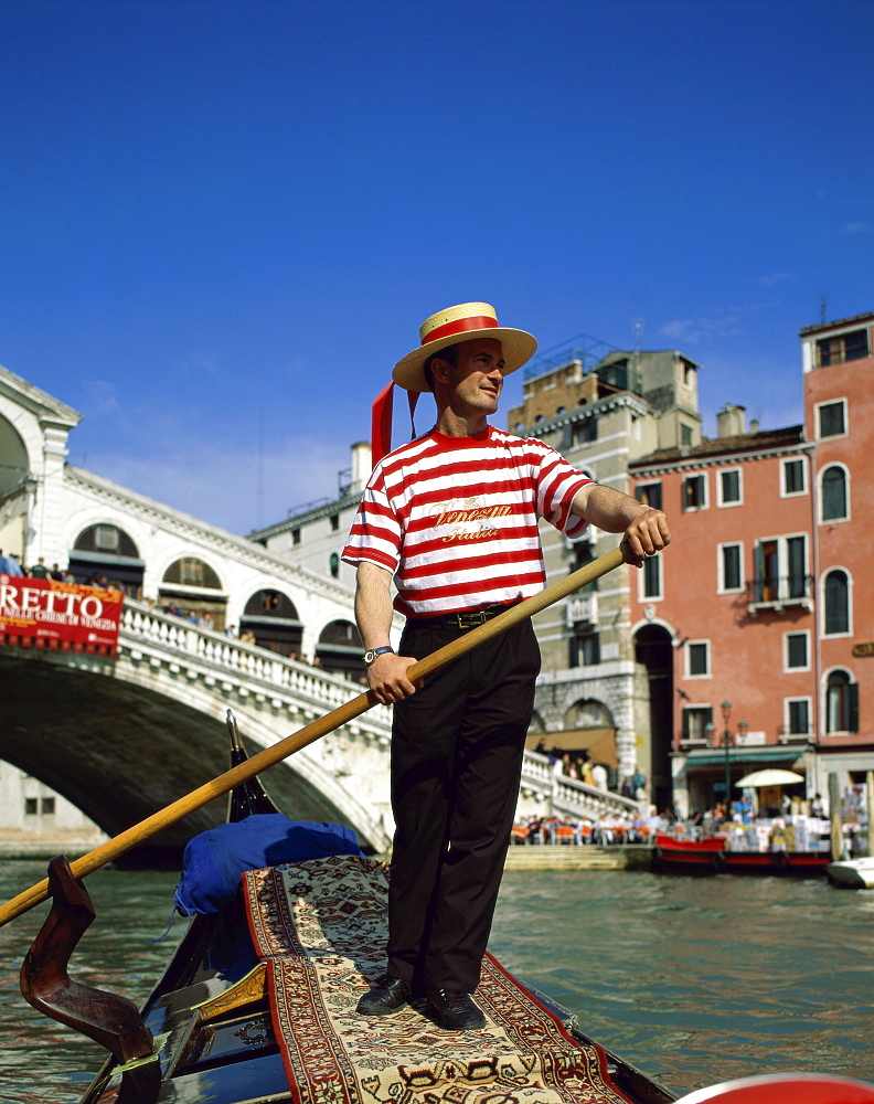 Gondolier on the Grand Canal (Canal Grande) by the Rialto Bridge (Ponte di Rialto), Venice, UNESCO World Heritage Site, Veneto, Italy, Europe