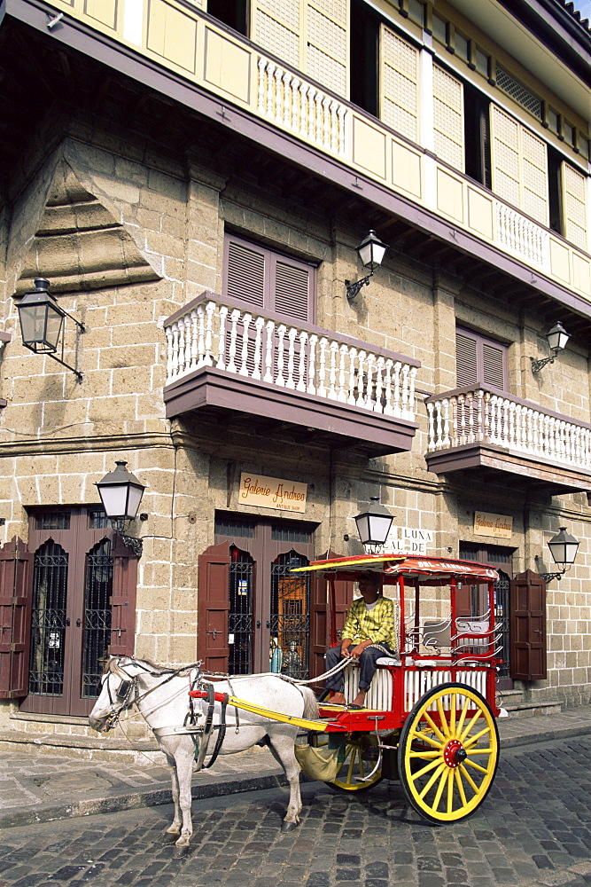 Calesa (horse drawn carriage) and Spanish colonial building in the Intramuros Historical District, Manila, Philippines, Southeast Asia, Asia